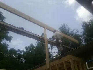 Carpenter setting a ridge beam over a new addition frame — Ice Dam Removal by Roofing Brothers in Modena
