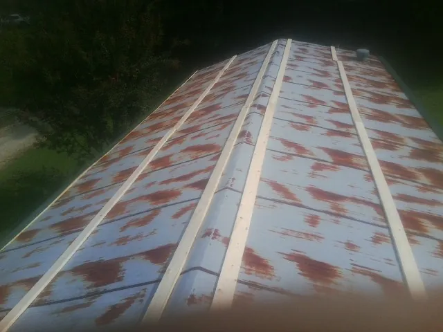 Rusted metal roof panels with new wood purlins before replacement — Storm Damage Roof Repair in Modena by Roofing Brothers
